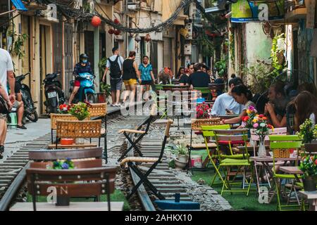 Il turista a godere di outdoor cafe posti a sedere sulle vie di Hanoi la famigerata treno Street, Ong 224 Le Duan, nel vecchio quartiere Foto Stock