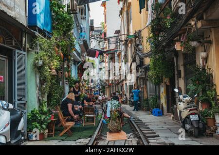 Il turista a godere di outdoor cafe posti a sedere sulle vie di Hanoi la famigerata treno Street, Ong 224 Le Duan, nel vecchio quartiere Foto Stock