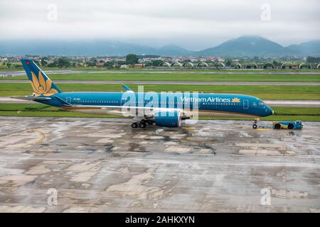 Un Airbus A350-900 azionato dal Vietnam Airlines viene trainato da un rimorchiatore all'Aeroporto Internazionale di Noi Bai, Hanoi, Vietnam Foto Stock