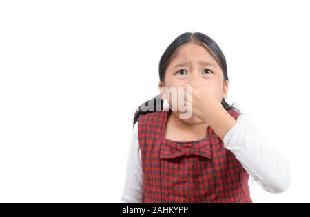 Ragazza asiatica mentre tiene il suo naso a causa di un cattivo odore isolati su sfondo bianco, il concetto di salute Foto Stock