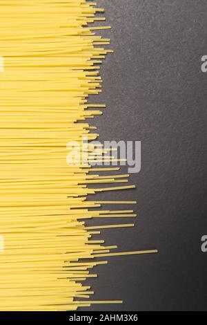 Materie italiano spaghetti su sfondo grigio scuro Foto Stock