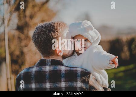 Little Boy indossando bianco doposci essendo portati dal suo papà Foto Stock