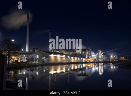 Cantley barbabietola da zucchero di fabbrica attraverso il lavoro le ore scure, edifici riflessa nel fiume y vengono, Norfolk Foto Stock