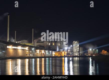 Cantley barbabietola da zucchero di fabbrica attraverso il lavoro le ore scure, edifici riflessa nel fiume y vengono, Norfolk Foto Stock