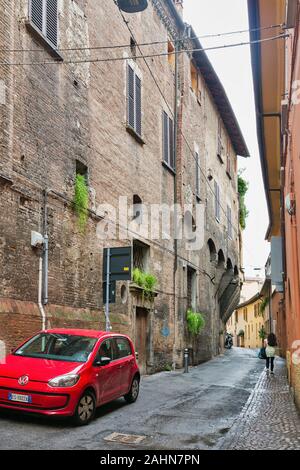 BOLOGNA, Italia - 10 luglio 2019: Donna a piedi lungo l'antica strada stretta sotto la pioggia. Bologna è la settima città più popolosa d'Italia. Foto Stock