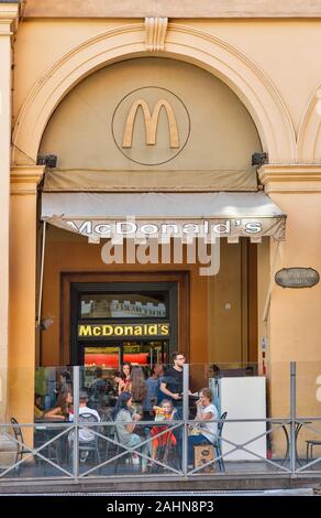 BOLOGNA, Italia - 10 luglio 2019: la gente visita ristorante McDonald's in città il centro storico. È un americano di fast food company fondata nel 1940 come una res Foto Stock