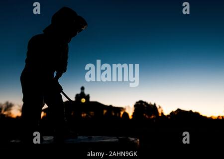 Pinehurst, North Carolina, Stati Uniti d'America. 31 Dic, 2019. Dicembre 31, 2019 - PINEHURST, N.C., STATI UNITI D'AMERICA - Il Putter Boy statua a Pinehurst Resort & Country Club saluta l'ultima alba del 2019. La statua, un simbolo iconico del resort era conosciuta come "La Meridiana Boy' fino agli anni settanta, quando 'il putter Boy' nome catturati su. Per molti anni la statua seduto su una base in cemento tra le due grandi putting greens accanto al clubhouse. Credito: ZUMA Press, Inc./Alamy Live News Foto Stock