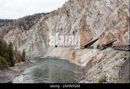 Vetture di osservazione o carrelli sulle rocky mountaineer treno passa attraverso il terreno roccioso accanto al Thompson River, Canada Foto Stock