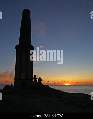 Un paio di prendere una fotografia del sole al tramonto a Cape Cornwall, Cornwall, South West England, Regno Unito Foto Stock