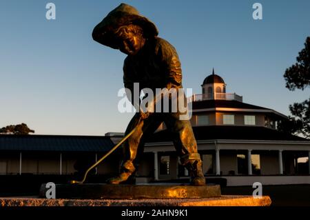 Pinehurst, North Carolina, Stati Uniti d'America. 31 Dic, 2019. Dicembre 31, 2019 - PINEHURST, N.C., STATI UNITI D'AMERICA - Il Putter Boy statua a Pinehurst Resort & Country Club saluta l'ultima alba del 2019. La statua, un simbolo iconico del resort era conosciuta come "La Meridiana Boy' fino agli anni settanta, quando 'il putter Boy' nome catturati su. Per molti anni la statua seduto su una base in cemento tra le due grandi putting greens accanto al clubhouse. Credito: ZUMA Press, Inc./Alamy Live News Foto Stock