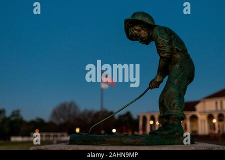 Pinehurst, North Carolina, Stati Uniti d'America. 31 Dic, 2019. Dicembre 31, 2019 - PINEHURST, N.C., STATI UNITI D'AMERICA - Il Putter Boy statua a Pinehurst Resort & Country Club saluta l'ultima alba del 2019. La statua, un simbolo iconico del resort era conosciuta come "La Meridiana Boy' fino agli anni settanta, quando 'il putter Boy' nome catturati su. Per molti anni la statua seduto su una base in cemento tra le due grandi putting greens accanto al clubhouse. Credito: ZUMA Press, Inc./Alamy Live News Foto Stock