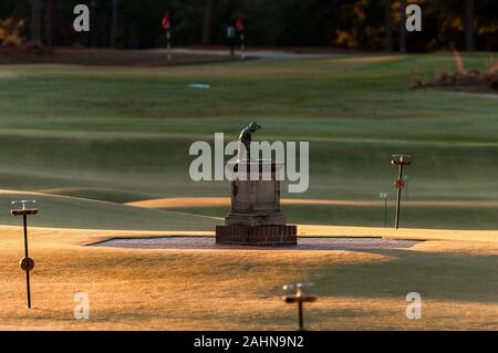 Pinehurst, North Carolina, Stati Uniti d'America. 31 Dic, 2019. Dicembre 31, 2019 - PINEHURST, N.C., STATI UNITI D'AMERICA - Il Putter Boy statua a Pinehurst Resort & Country Club saluta l'ultima alba del 2019. La statua, un simbolo iconico del resort era conosciuta come "La Meridiana Boy' fino agli anni settanta, quando 'il putter Boy' nome catturati su. Per molti anni la statua seduto su una base in cemento tra le due grandi putting greens accanto al clubhouse. Credito: ZUMA Press, Inc./Alamy Live News Foto Stock