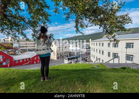 Akureyri, Islanda - 17 July, 2018 ragazza adolescente soggiornando in collina di fronte al centro cittadino di Akureyri, capitale del Nordurland eystra regione nel nord di IO Foto Stock