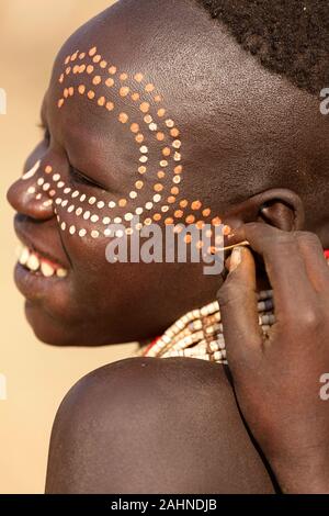 Giovani donne dalla tribù Karo pittura ogni altra faccia con il modello tradizionale, valle dell'Omo, Etiopia, Africa Foto Stock