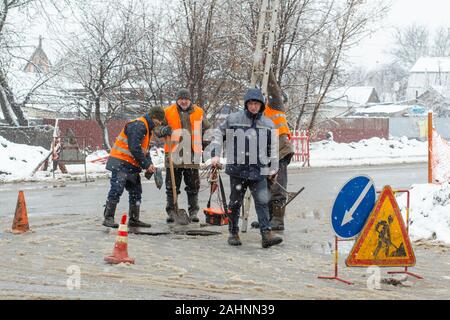 Città del servizio di emergenza di riparazione rottura tubo acqua in inverno. Foto Stock