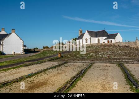 Gioco Bouling posto nel villaggio di Hoedic isola in francese Brittany, Francia., la chiesa di Notre Dame la Blanche è in background. Brittany Foto Stock