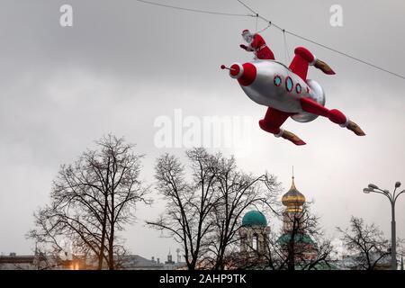 Mosca, Russia. 31 dicembre 2019 una persona vestita come Padre Frost vola un razzo al di sopra del centro di Mosca come parte del viaggio al festival di Natale, Russia Foto Stock