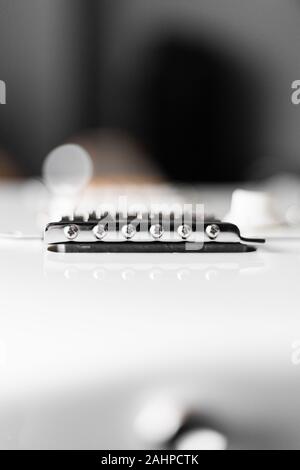 Tremolo whammy ponte di white Stratocaster chitarra con sfondo sfocato profondità di campo per bokeh di fondo Foto Stock