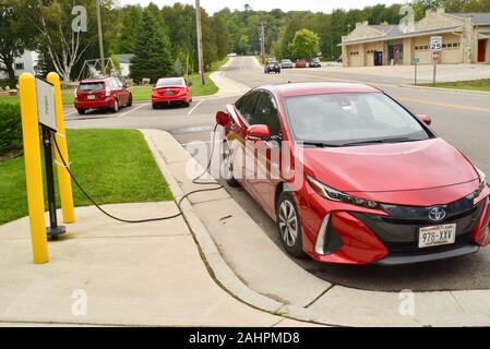 Auto elettrica ibrida plug-in, una Toyota Prius prime 2017 rossa di Barcellona, che si ricarica nella comunità Door County di Baileys Harbor, Wisconsin, Stati Uniti Foto Stock