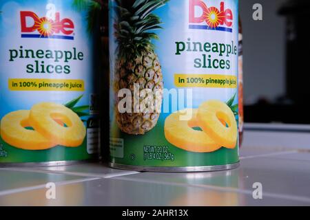 Due 20 once di lattine di lattina (567 grammi) di marchio Dole fette di ananas in 100% di succo di ananas su una cucina piastrellata contatore. Foto Stock