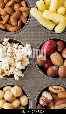 Una parte superiore verso il basso vista macro di un muffin stagno riempito con una varietà di spuntini. Foto Stock