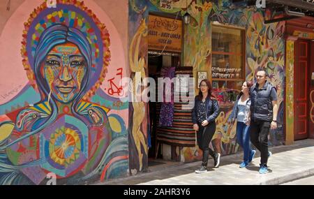 La gente camminare passato murale di artista urbano Rodez e graffiti dipinti su esterno dell edificio in Candelaria distretto di Bogotà, Colombia Foto Stock