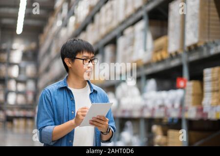 Ritratto uomini asiatici, staff, conteggio del prodotto di controllo Warehouse Manager in piedi, conteggio e il controllo di prodotti in magazzino Foto Stock