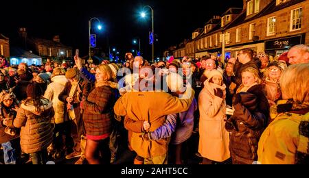 La folla per celebrare il Nuovo Anno 2020 al Biggar Hogmanay - il falò acceso alle 21.30 su Hogmanay da parte di un residente locale. Foto Stock