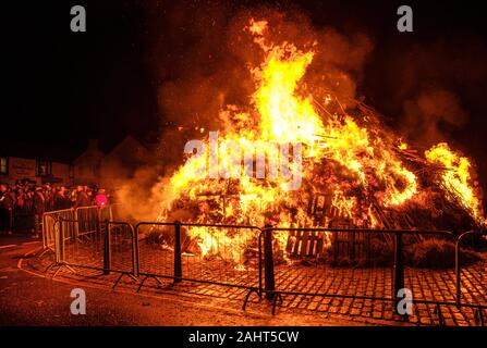 La folla per celebrare il Nuovo Anno 2020 al Biggar Hogmanay - il falò acceso alle 21.30 su Hogmanay da parte di un residente locale. Foto Stock