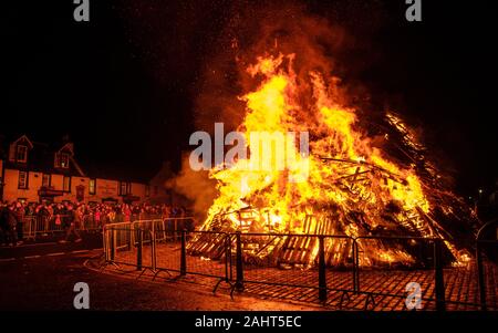 La folla per celebrare il Nuovo Anno 2020 al Biggar Hogmanay - il falò acceso alle 21.30 su Hogmanay da parte di un residente locale. Foto Stock