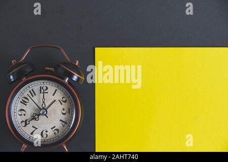 Vecchio retrò sveglia su un giallo e sfondo nero Foto Stock
