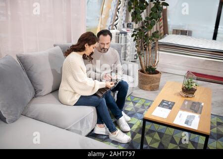 L uomo e la donna nel salone di mobili scegliendo i dettagli di mobili Foto Stock
