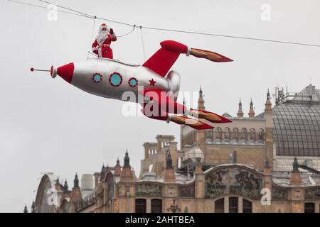 Mosca, Russia. 31 dicembre 2019 una persona vestita come Padre Frost vola un razzo al di sopra del centro di Mosca come parte del viaggio al festival di Natale, Russia Foto Stock