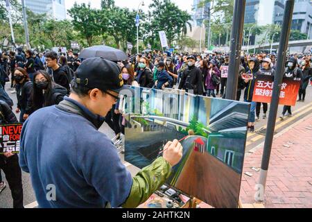 Gennaio 1, 2020, Hong Kong, migliaia di cittadini hanno partecipato a-in-un-protesta - marzo-su-New-Years-giorno-organizzato-per-il-Civil-Human-Rights-Front..Un-artista-vernici-la-protesta-in-Admiralty-District. Foto Stock