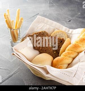 Cestino del pane nel ristorante, appena sfornato il cibo. Pasticceria francese concetto. Set di diversi tipi di pane e pasticceria. Foto Stock