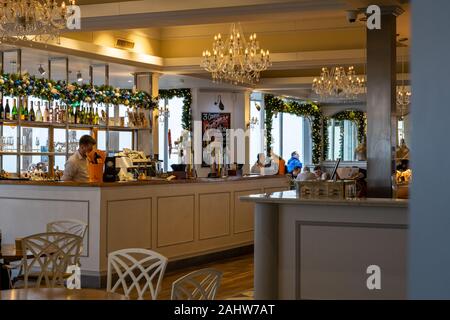 L'interno di un ristorante con un barman nel bar che serve bevande Foto Stock