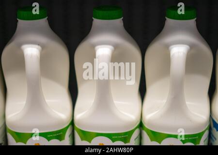 Scatole di plastica del latte su un ripiano in un supermercato Foto Stock