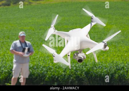 Pilota comandante dei velivoli senza pilota drone di raccogliere dati su terreni agricoli del paese campo. Foto Stock