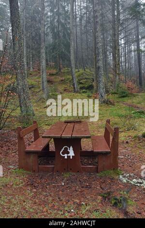 Picnic Panca e tavolo in foresta. Presa sul bagnato giornata invernale in Faskally boschi, Loch Dunmore vicino Pitlochry, Perthshire, Highlands scozzesi, REGNO UNITO Foto Stock