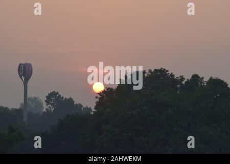 Sun nascondersi dietro la struttura ad albero, vista al tramonto, Chandigarh Foto Stock