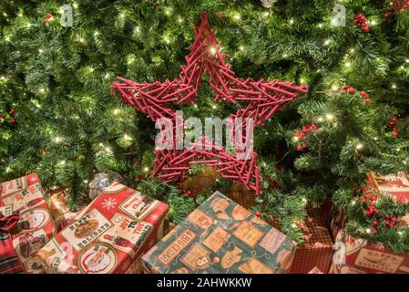 Le decorazioni di Natale e regali sotto un grande albero di Natale. Foto Stock