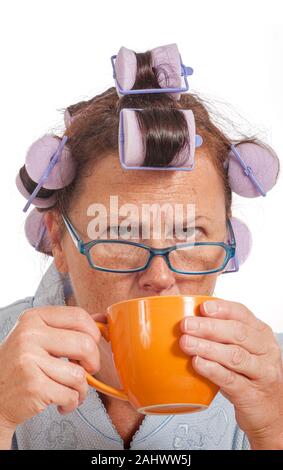 Colpo verticale di un burbero casalinga di bere il suo caffè del mattino. Foto Stock