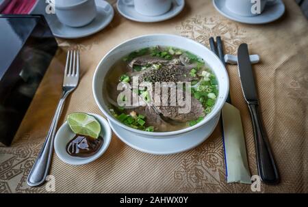 Tradizionale vietnamita Pho zuppa di riso noddles, manzo, polpettine di carne, cipolle fritte servite nel ristorante popolare o in hotel Foto Stock