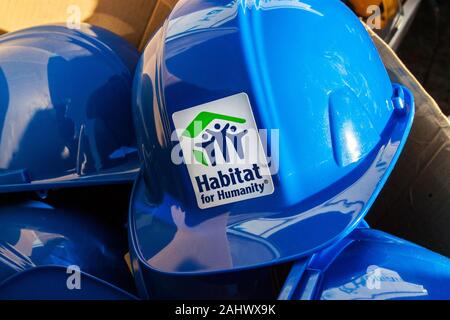 Un caso di blu Habitat for Humanity hardhats attendere per volontari Foto Stock