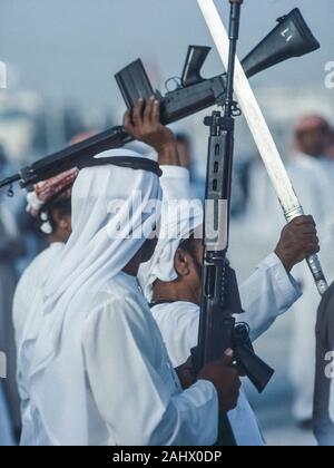 Dubai folklore araba, la cultura e la storia di un gruppo di Emirati uomini di raccolta per eseguire una spada e una pistola dance routine per celebrare il matrimonio di uno degli sceicchi dalla famiglia dominante quando tutti Emiratis sono invitati alla cerimonia e festeggiamenti negli Emirati Arabi Uniti Foto Stock