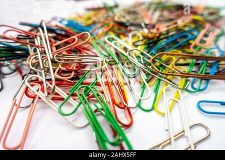 Una pila di fermagli per carta contro uno sfondo bianco. Foto Stock