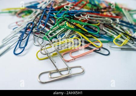 Una pila di fermagli per carta contro uno sfondo bianco. Foto Stock