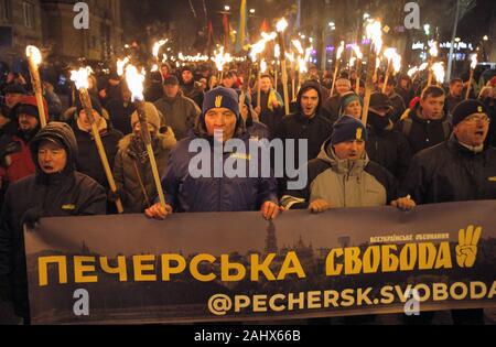 Kiev, Ucraina. 1a gen, 2020. Gli attivisti ucraini portano le torce durante un rally di diversi partiti nazionalisti per contrassegnare il 111° anniversario della Stepan Bandera compleanno in Kiev, Ucraina, 01 gennaio 2020. Stepan Bandera era uno dei leader della nazionale ucraina di circolazione nei territori occupati di Ucraina occidentale. Egli era responsabile per la proclamazione di indipendenza di uno Stato ucraino a Lviv il 30 giugno 1941. Stepan Bandera è stato uno dei fondatori dell'organizzazione dei nazionalisti ucraini (OUN) e l'Ucraino Esercito Ribelle, che durante la seconda guerra mondiale ha combattuto contro i sovietici e eserciti tedeschi. (Credito mi Foto Stock