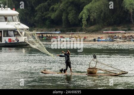 Pescatore Cormorant che rilascia una rete di cast, li River vicino Xingping Fishing Village, provincia Guangxi, Cina Foto Stock