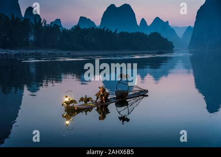 Pescatore Cormorant che prende la pausa di fumo di mattina presto, fiume li, Xingping, Guilin, Cina Foto Stock